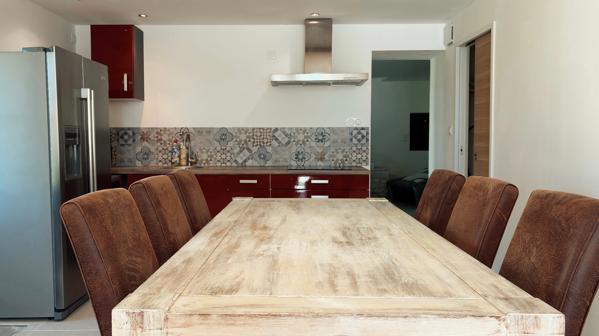 Cuisine équipée et grande table de repas en bois pour six convives